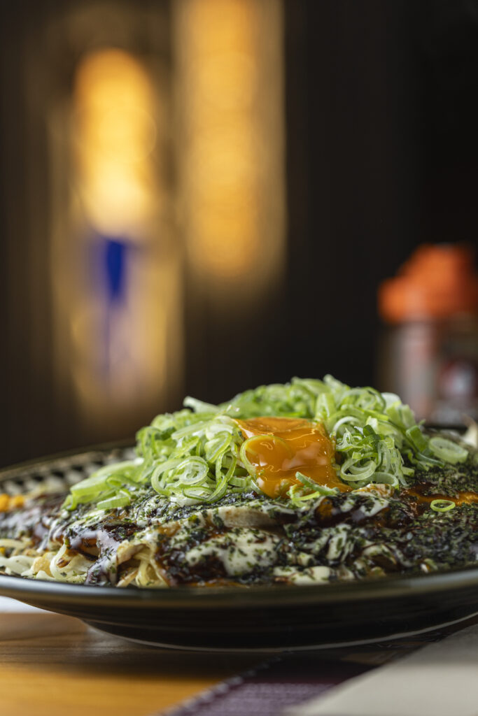 Chef preparando el auténtico okonomiyaki en la plancha teppan de Okonomi San Madrid.